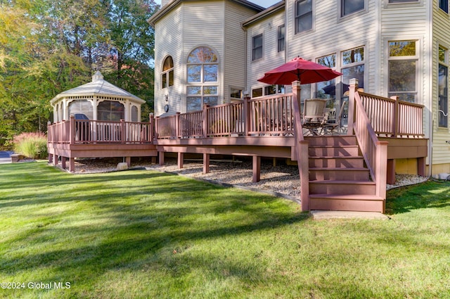 rear view of house featuring a gazebo, a deck, and a yard