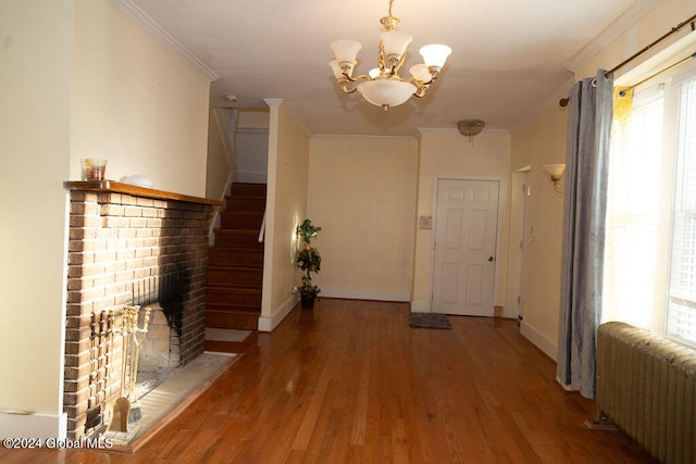 corridor featuring ornamental molding, hardwood / wood-style floors, radiator heating unit, and a chandelier