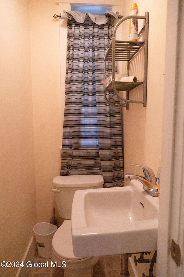 bathroom featuring sink, curtained shower, toilet, and tile patterned flooring