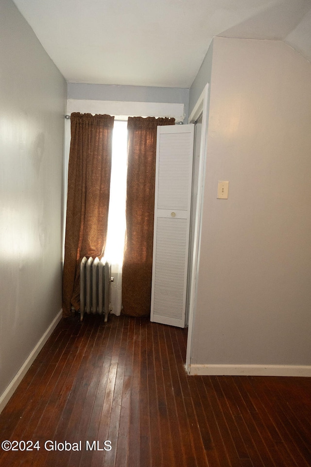 empty room with radiator and dark hardwood / wood-style floors