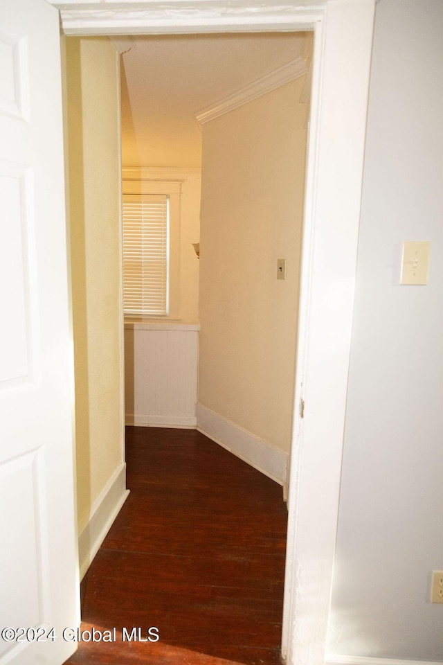 hall with wood finished floors, baseboards, and crown molding