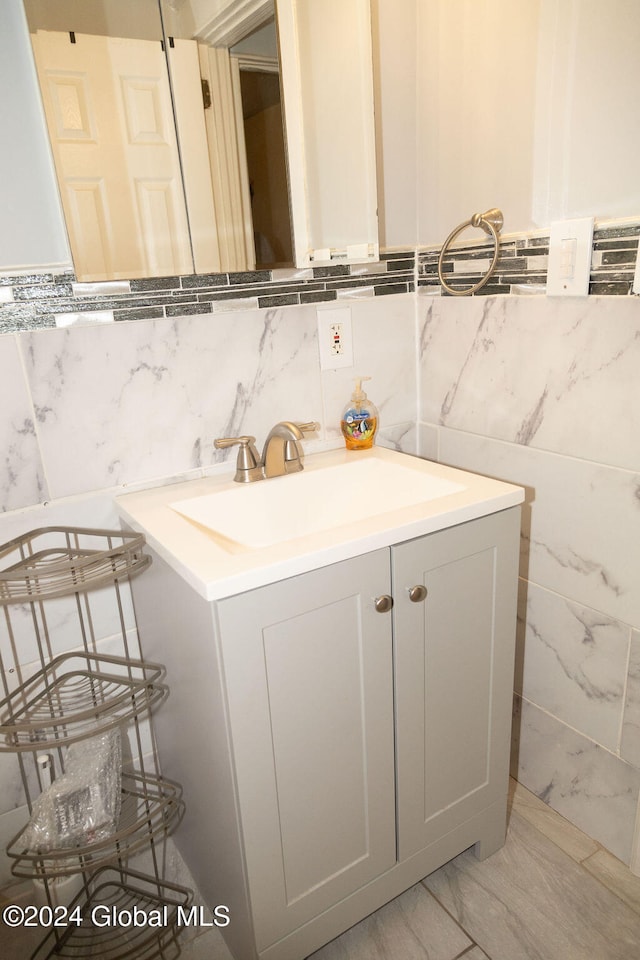 bathroom with vanity and tile walls