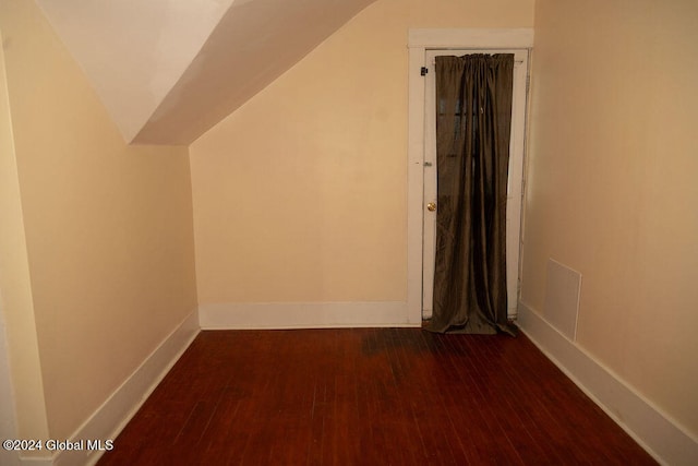 additional living space featuring vaulted ceiling and dark hardwood / wood-style flooring