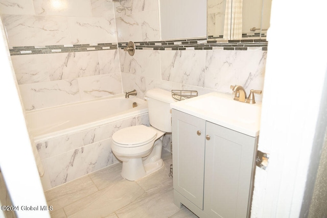 full bathroom with vanity, tiled shower / bath combo, toilet, and tile walls