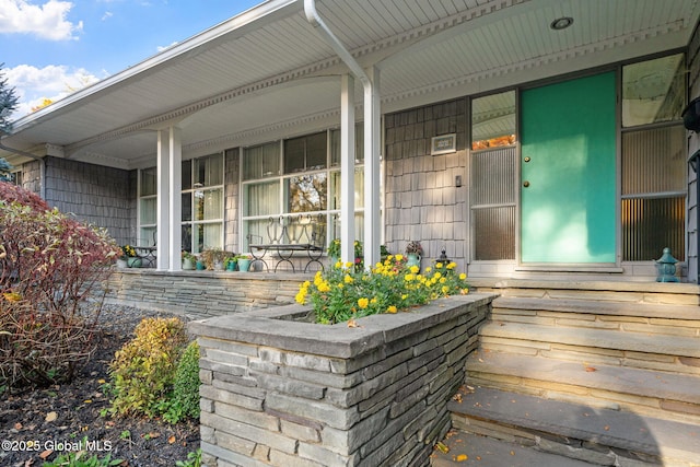 view of exterior entry featuring covered porch