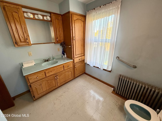 bathroom with radiator heating unit, vanity, and toilet