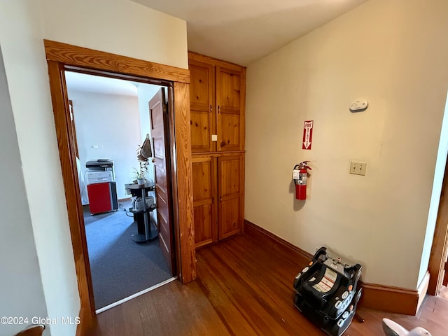 hallway with dark hardwood / wood-style flooring