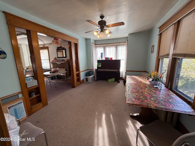 interior space with ceiling fan and a brick fireplace