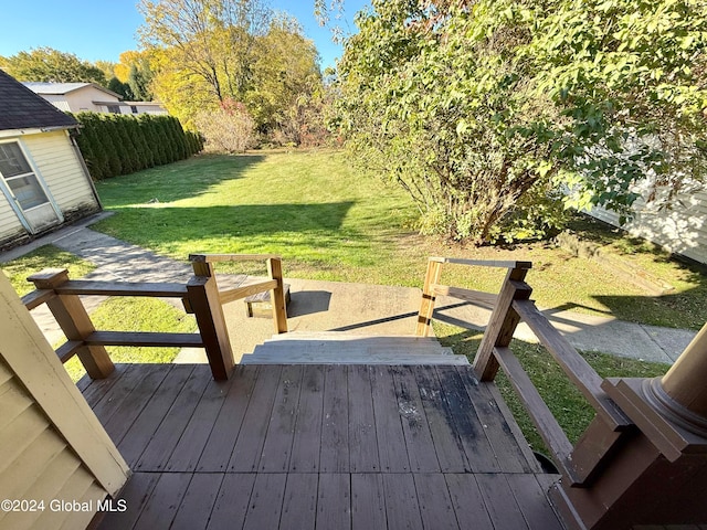 wooden terrace featuring a lawn