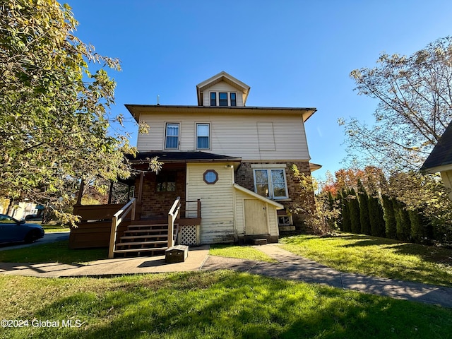 view of front of home featuring a deck and a front lawn