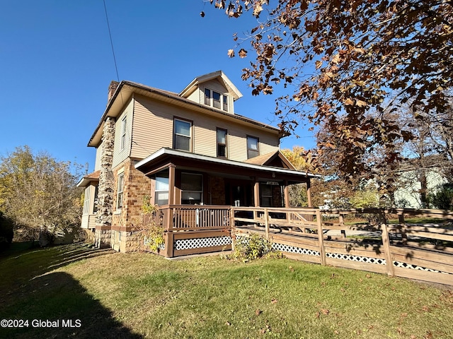 view of front of house with covered porch and a front lawn