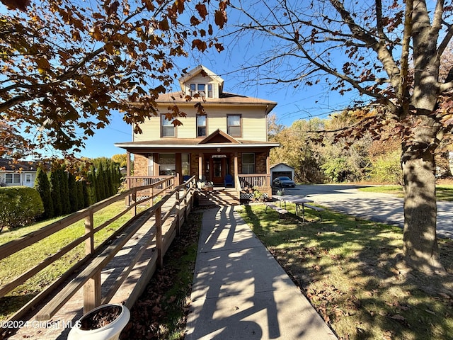 view of front of home featuring a porch, an outbuilding, and a garage