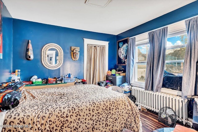 bedroom featuring hardwood / wood-style flooring and radiator heating unit