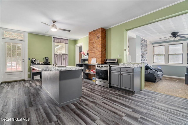 kitchen featuring sink, crown molding, stainless steel gas range, gray cabinets, and dark hardwood / wood-style flooring