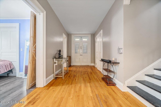 foyer entrance with light hardwood / wood-style floors and french doors