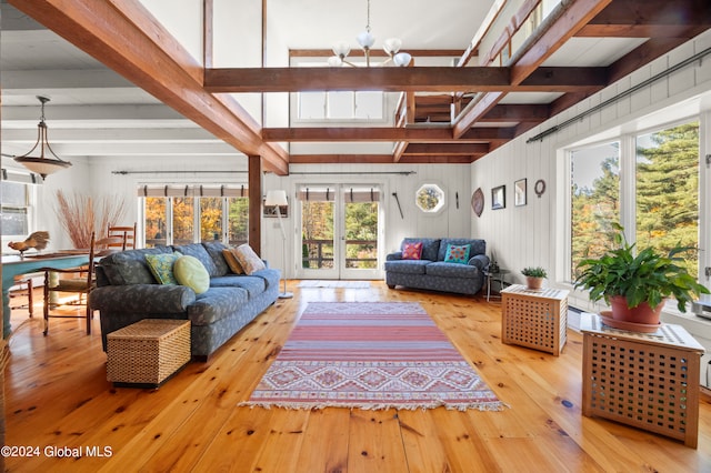 sunroom with an inviting chandelier, french doors, and beamed ceiling