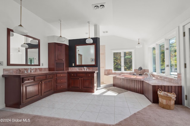 bathroom featuring vanity, a tub to relax in, tile patterned flooring, and vaulted ceiling