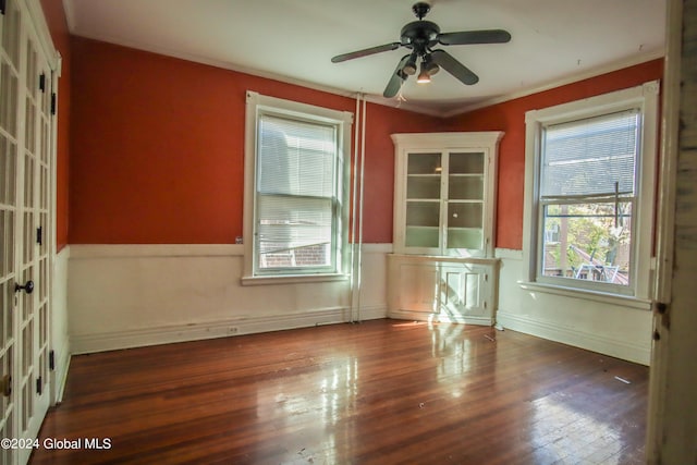 empty room featuring crown molding, dark wood-type flooring, and ceiling fan