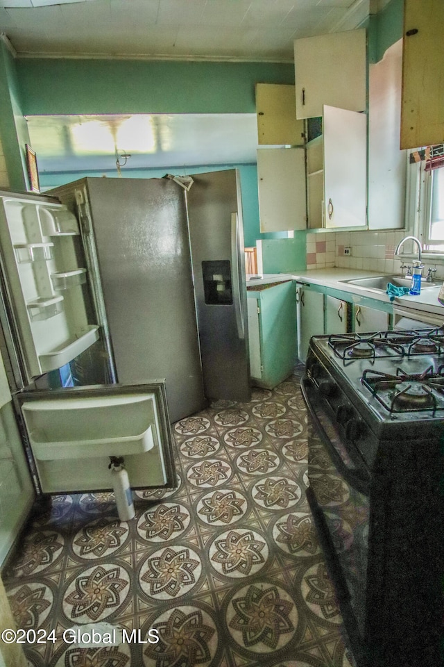 kitchen with black range with gas cooktop, sink, stainless steel fridge with ice dispenser, and backsplash