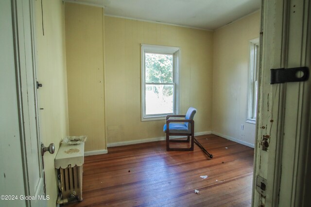 living area featuring ornamental molding and dark wood-type flooring