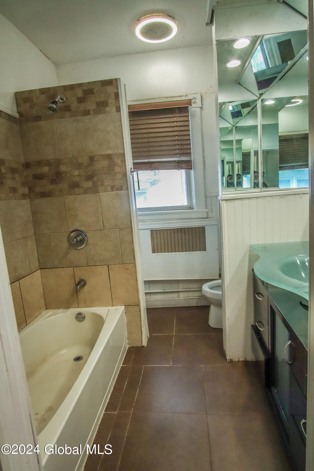 full bathroom featuring vanity, tiled shower / bath combo, toilet, and tile patterned flooring