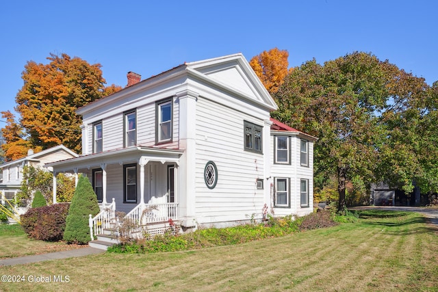 neoclassical / greek revival house with a front yard and covered porch