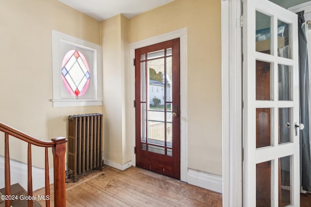 entryway with radiator heating unit and wood-type flooring