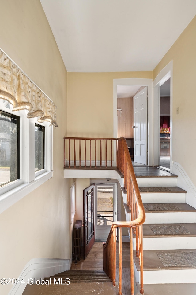 stairs featuring hardwood / wood-style floors