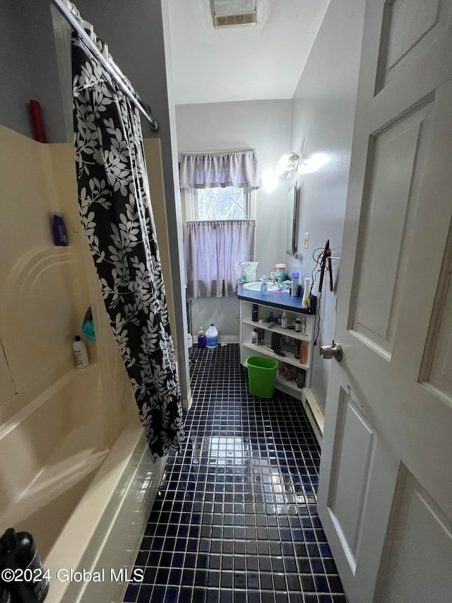 bathroom with shower / tub combo with curtain and tile patterned floors