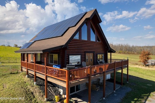 rear view of house with a deck, a yard, and a rural view