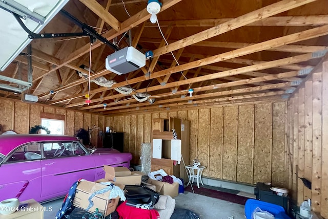 garage with a garage door opener and wooden walls