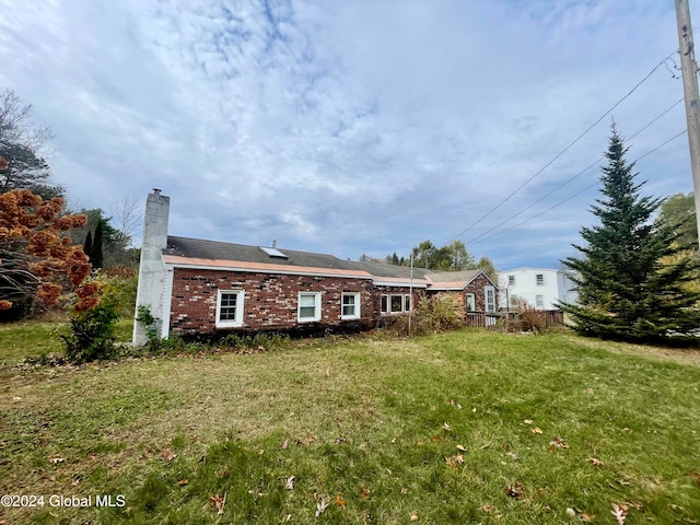 rear view of property featuring a yard