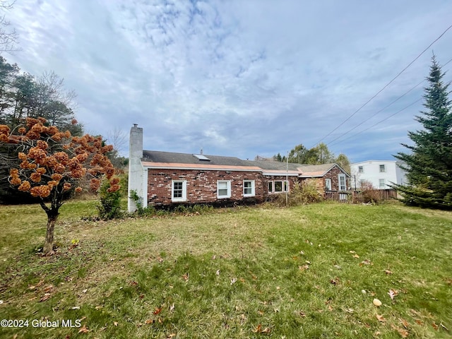 rear view of house featuring a lawn