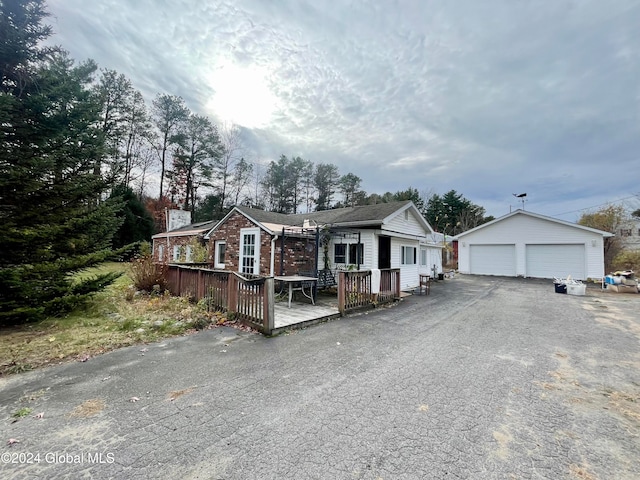 view of front of house with a garage, an outdoor structure, and a wooden deck