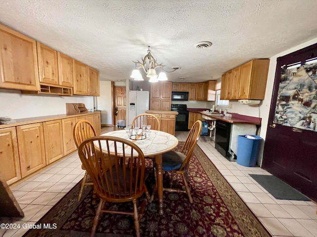 kitchen featuring black appliances, a textured ceiling, a notable chandelier, light tile patterned floors, and pendant lighting