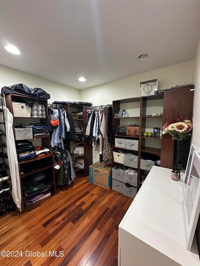 walk in closet with dark hardwood / wood-style floors