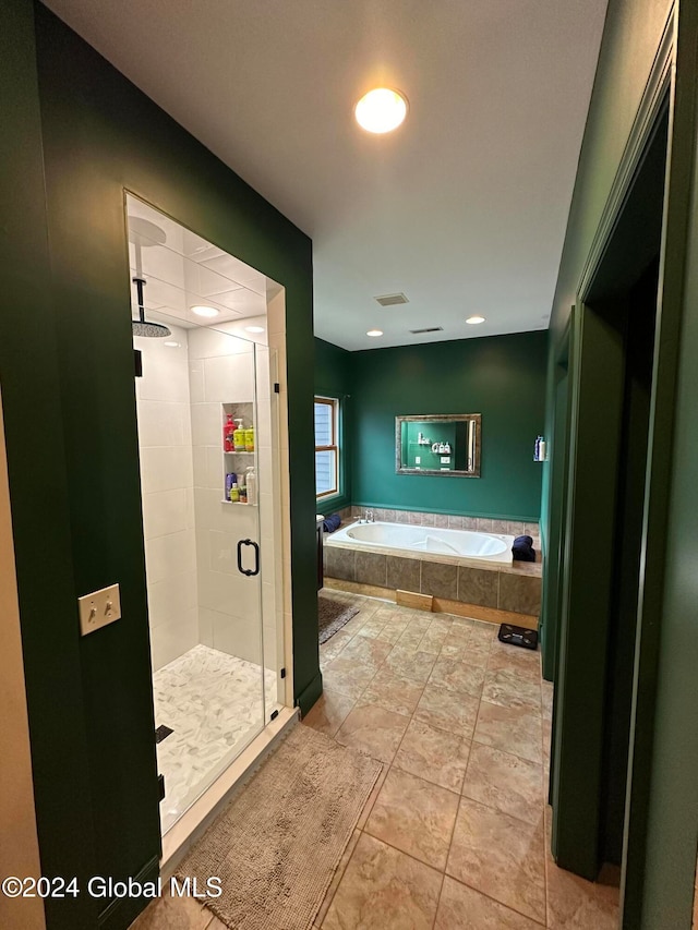 bathroom with independent shower and bath and tile patterned flooring