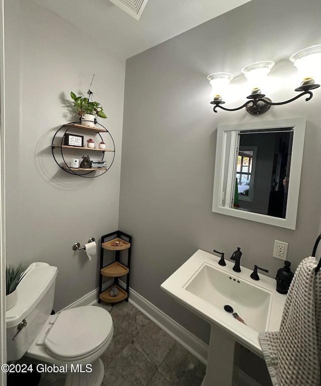 bathroom featuring sink, toilet, and tile patterned flooring