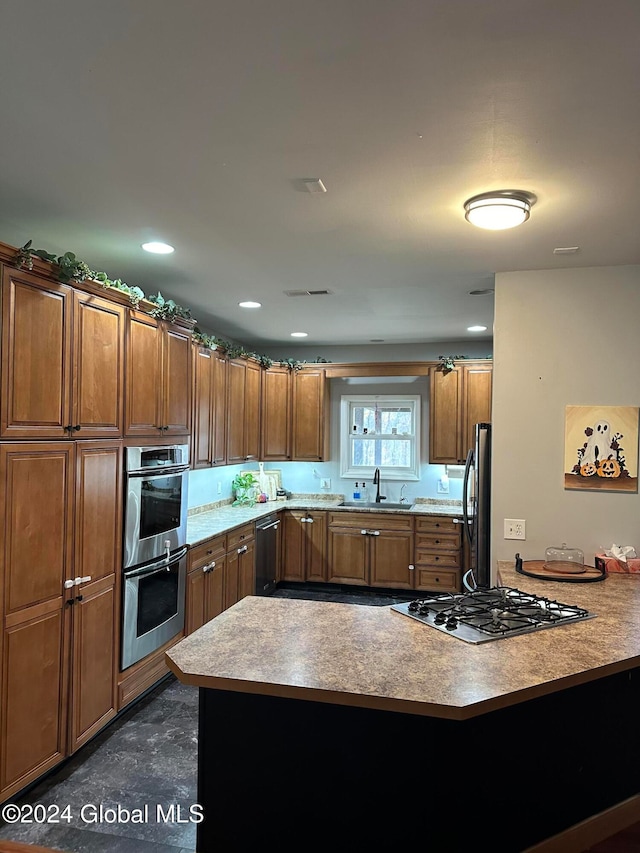 kitchen with kitchen peninsula, stainless steel appliances, and sink