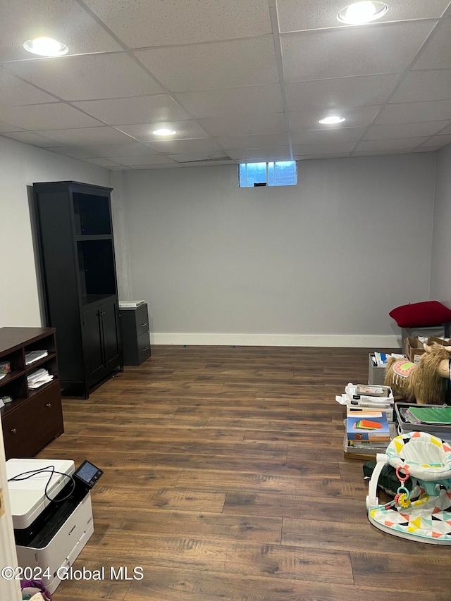 game room with dark wood-type flooring and a paneled ceiling