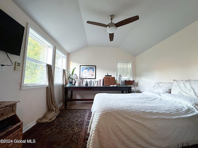 bedroom with ceiling fan, dark wood-type flooring, and vaulted ceiling