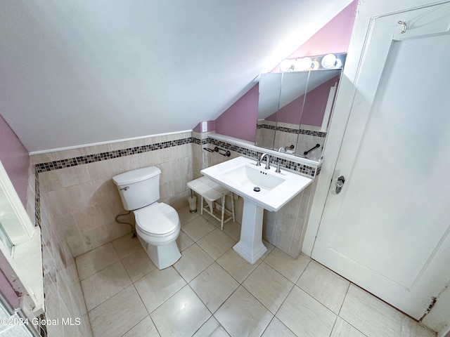 bathroom featuring toilet, tile patterned floors, tile walls, and sink