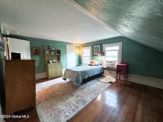 bedroom featuring cooling unit, wood-type flooring, and vaulted ceiling