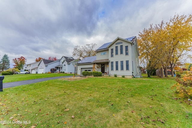 view of front of home with a front yard and a garage