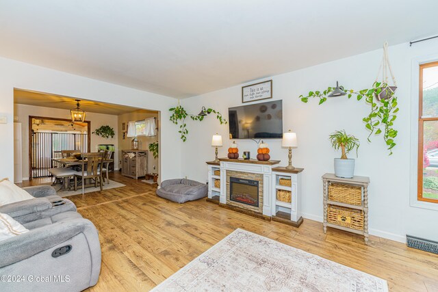 living room with hardwood / wood-style floors and a stone fireplace