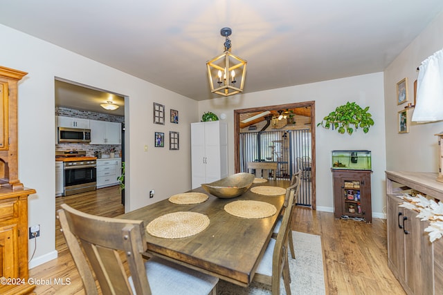 dining space with light hardwood / wood-style flooring and ceiling fan with notable chandelier