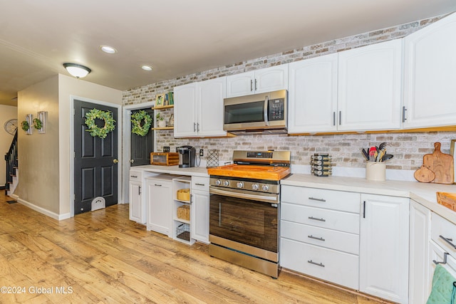 kitchen featuring white cabinets, light hardwood / wood-style flooring, and stainless steel appliances