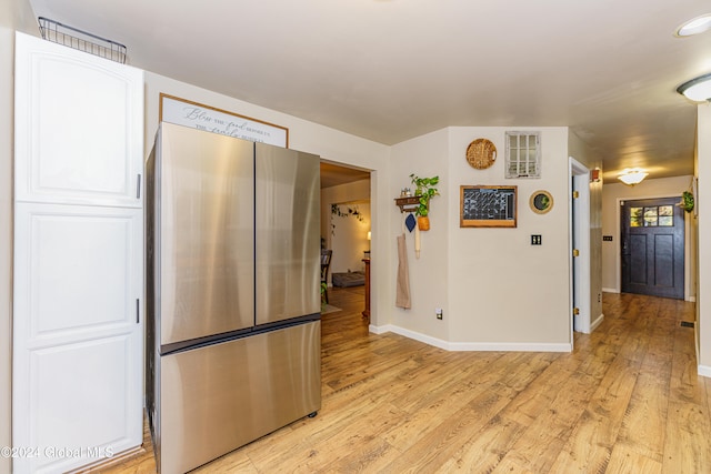 kitchen featuring white cabinetry, light hardwood / wood-style flooring, and stainless steel fridge