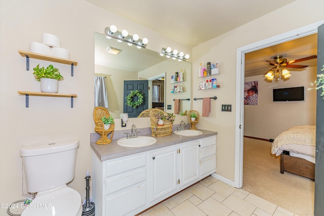 bathroom with toilet, vanity, and ceiling fan