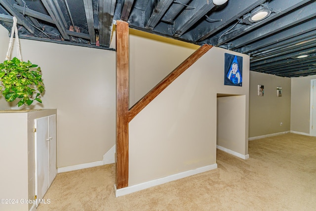 basement featuring light carpet